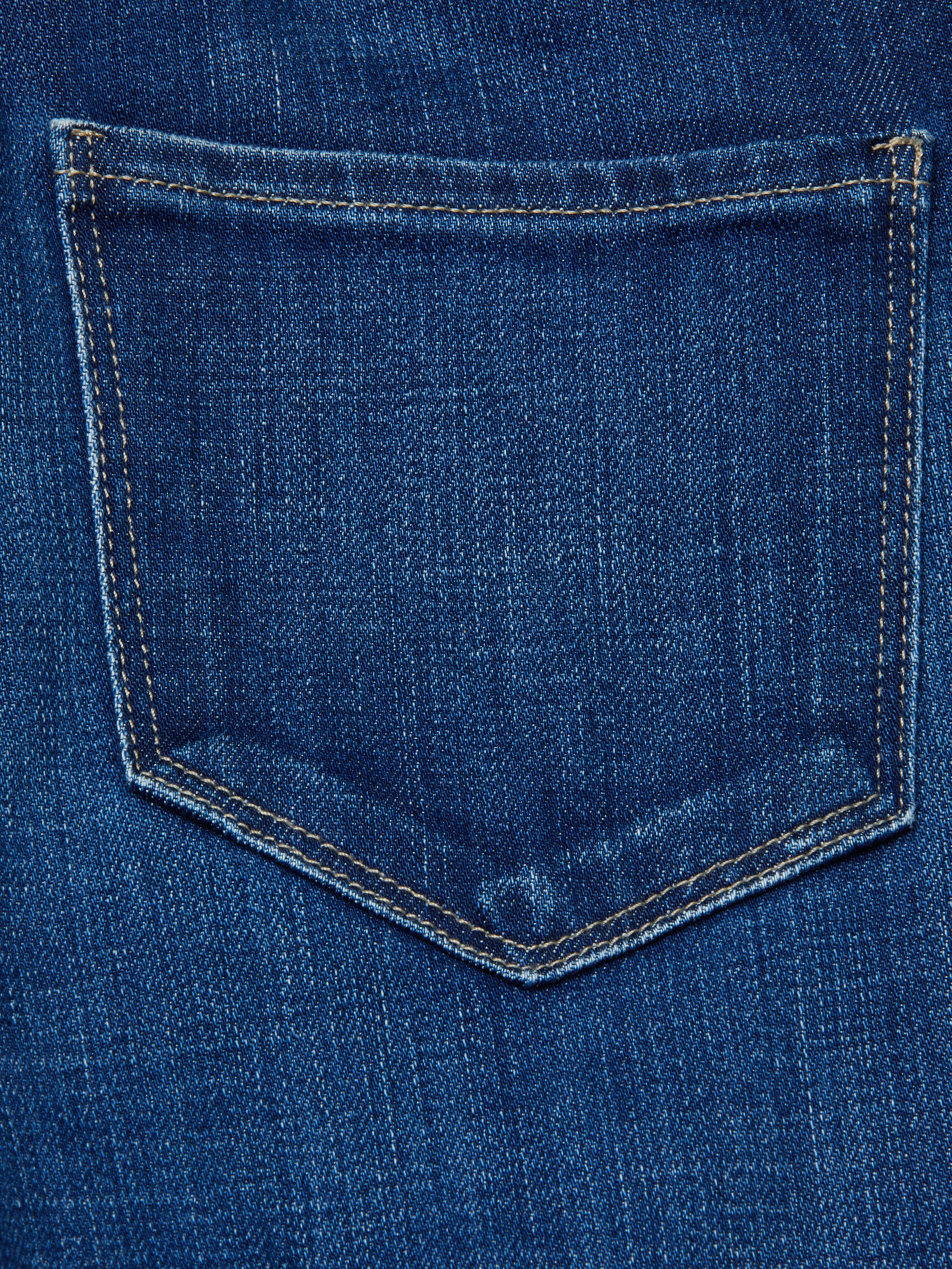 Close-up of the back pocket on the Celestia Slim-Leg Jean, featuring blue denim and visible yellow stitching around the edges.