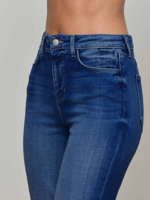 A close-up of a person wearing L'AGENCE Celestia Slim-Leg Jean in a vintage wash, highlighting the ultra high rise waist, hips, and upper thighs against a plain light background.