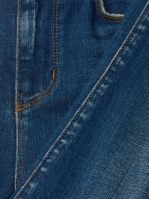 Close-up of Celestia Slim-Leg Jean in blue stretch denim, highlighting a front pocket with orange stitching and textured fabric. One leg is angled over the other.