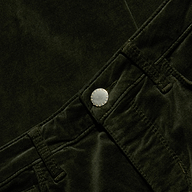 Close-up of the Celestia Velvet Slim-Leg Jean in dark green, featuring the waistband, belt loops, and metallic button, with emphasis on the texture and details of the stretch velvet fabric and stitching.