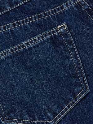 Close-up of the back pocket on L'AGENCE's Savina Low-Rise Wide-Leg Jean, highlighting detailed stitching and the texture of indigo-wash denim fabric.