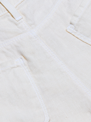 Close-up of white linen fabric with visible stitching and two pockets, featured on the Amara Linen Wide-Leg Pant.