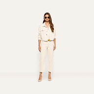A person wearing a cropped cream jacket, matching high-rise cream Mallis Corduroy Bow-Leg Pant, and tan heels.