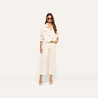 A person wears a cropped cream-colored jacket, matching tank top, and Mallis Corduroy Bow-Leg Pant with a gold-tone belt, paired with beige pumps and sunglasses.