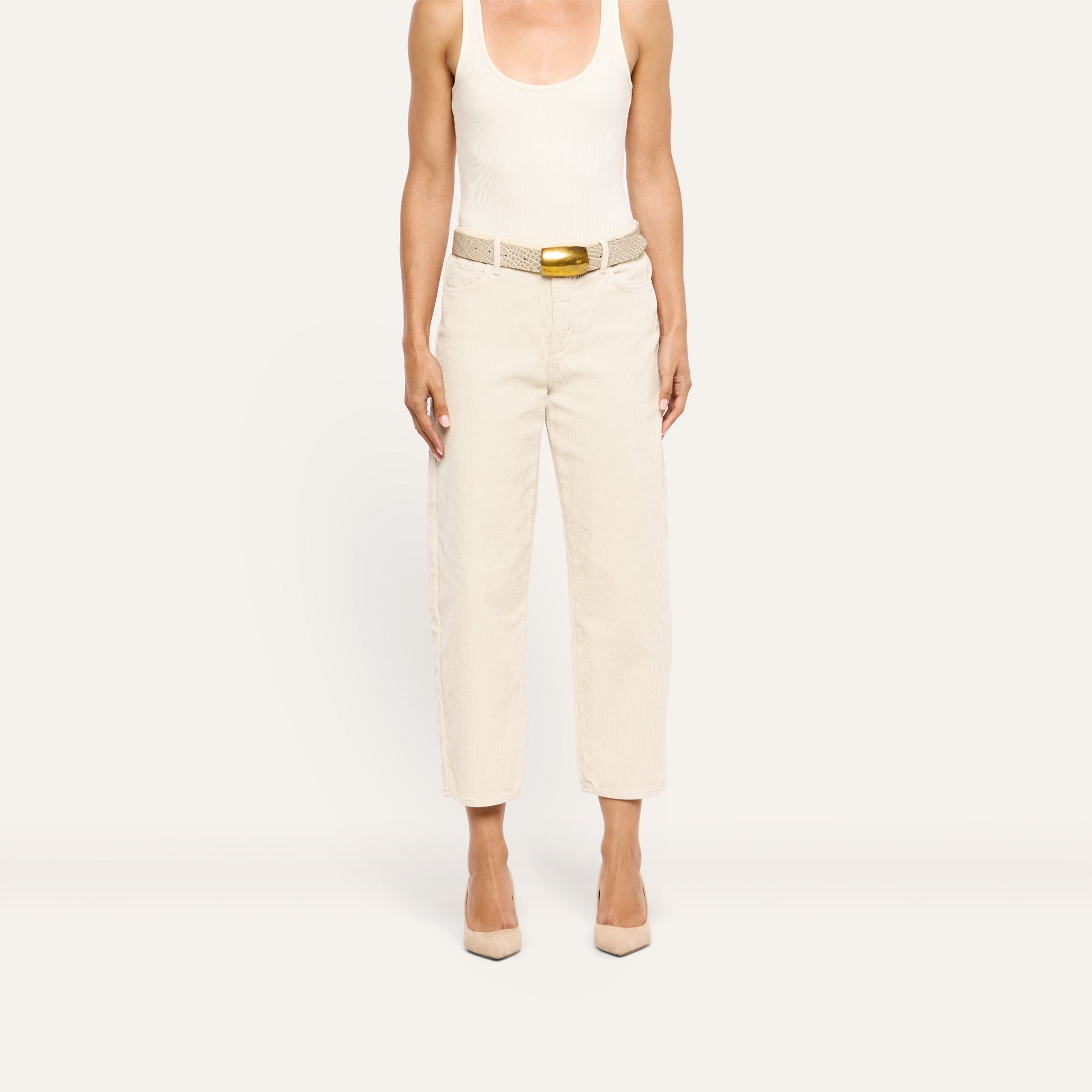 Mallis Corduroy Bow-Leg Pant in cream, featuring a high-rise, relaxed wide-leg silhouette styled with a textured belt with a gold buckle and pointed-toe heels.