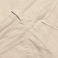 Close-up of the beige Mallis Corduroy Bow-Leg Pant, showing the texture of the vertical wales, a belt loop, and pocket stitching on this high-rise silhouette.