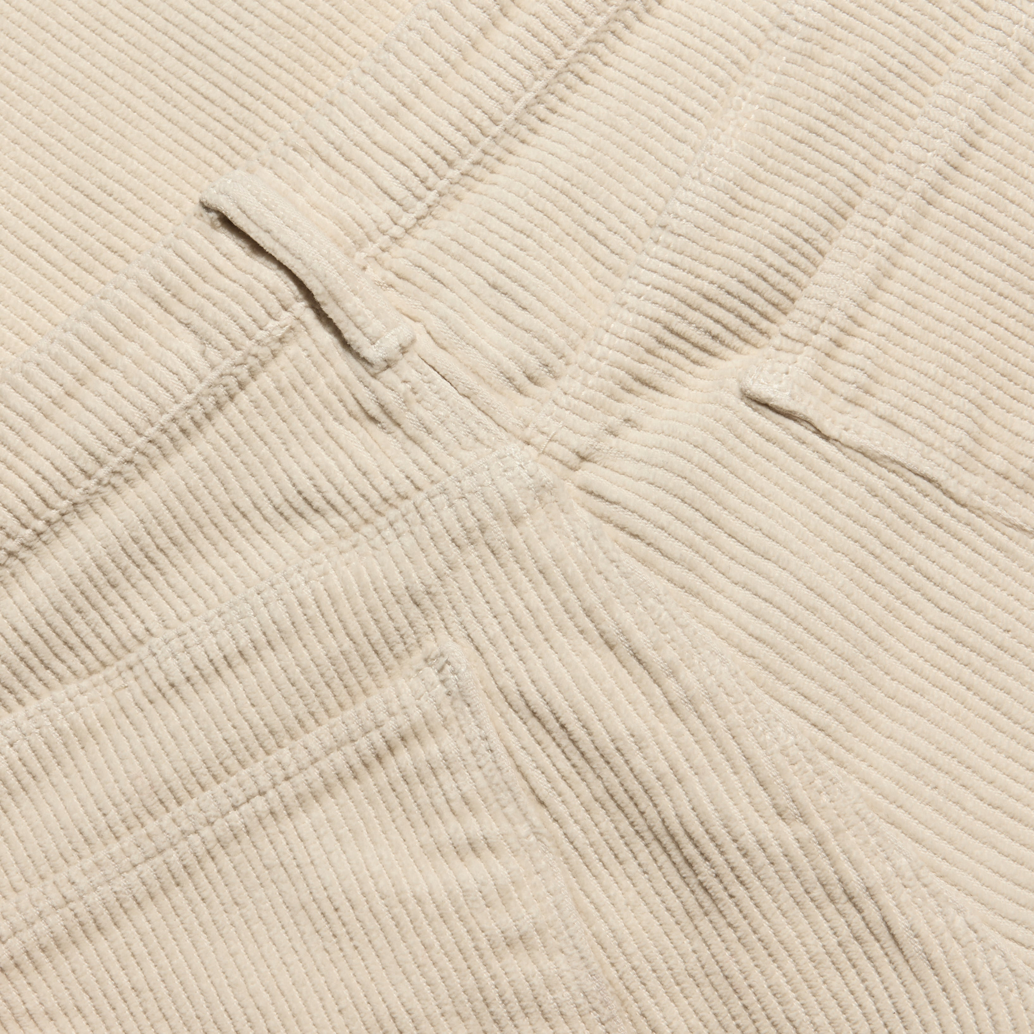 Close-up of the beige Mallis Corduroy Bow-Leg Pant, showing the texture of the vertical wales, a belt loop, and pocket stitching on this high-rise silhouette.