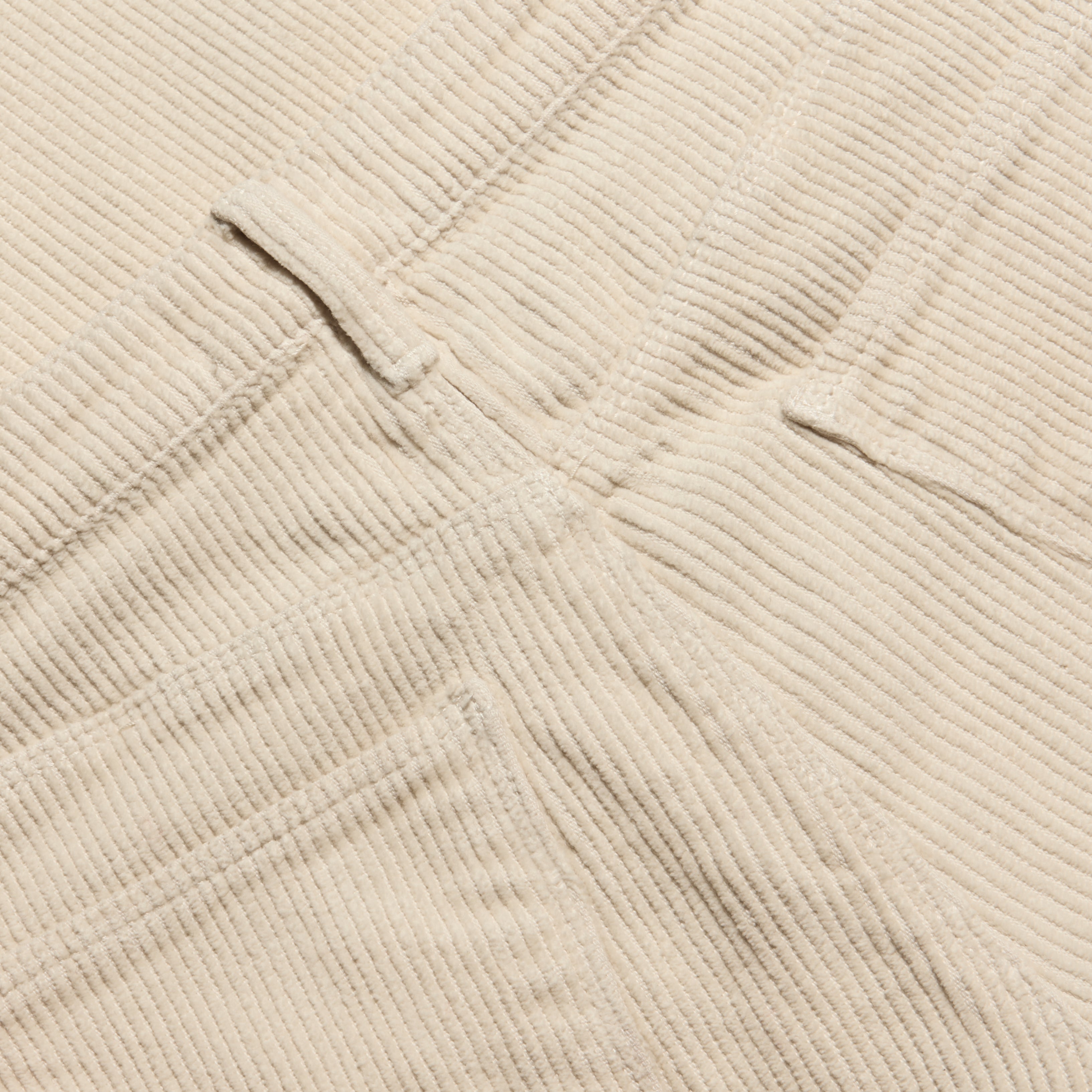 Close-up of the beige Mallis Corduroy Bow-Leg Pant, showing the texture of the vertical wales, a belt loop, and pocket stitching on this high-rise silhouette.