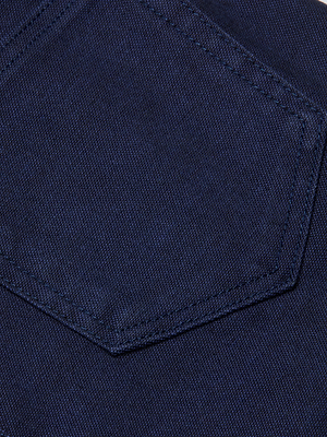 Close-up of a dark indigo wash denim fabric from the Mallis Bow-Leg Jean. A stitched pocket, typical of this high-rise wide-leg style, features straight seams and showcases the rich texture of the denim.