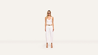A woman in sunglasses, a white sleeveless top, white wide-leg pants, and beige heels stands against a plain, light background, accentuating her look with a brown belt.