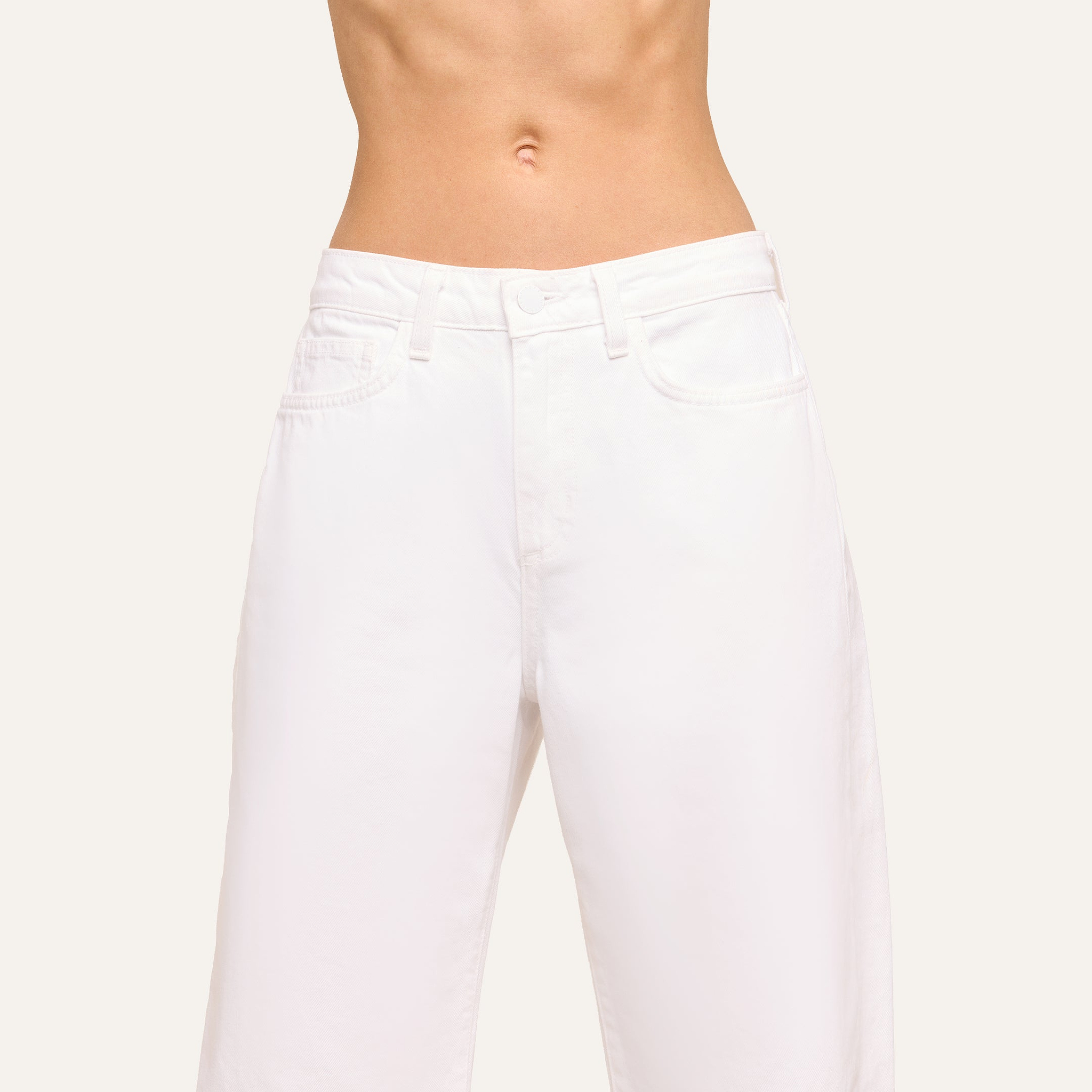 A person in Mallis Bow-Leg Jean stands against a plain, light background. The image is cropped from just below the chest to mid-thigh.