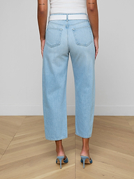 A person wearing the Mallis Bow-Leg Jean in a light wash and high heels stands with their back to the camera against a plain white background.