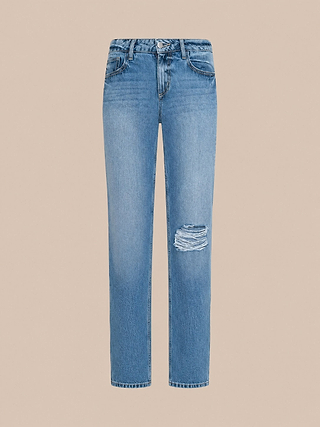 Jean « Armida » taille basse et coupe ample, de couleur bleu clair, présentant une coupe droite et décontractée avec une seule déchirure sur la cuisse droite, confectionné en denim vintage et présenté sur fond beige.