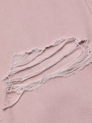 Close-up of light pink denim with a large horizontal tear and frayed edges reveals the Armida Low-Rise Slouch Jean's inner layer—ideal inspiration for creating your own distressed look.