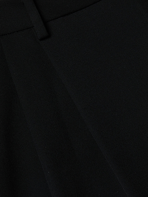 Close-up of black fabric from the Chelsy Wide-Leg Pant by L'AGENCE, highlighting the waistband, belt loop, pleat, and visible weave texture.