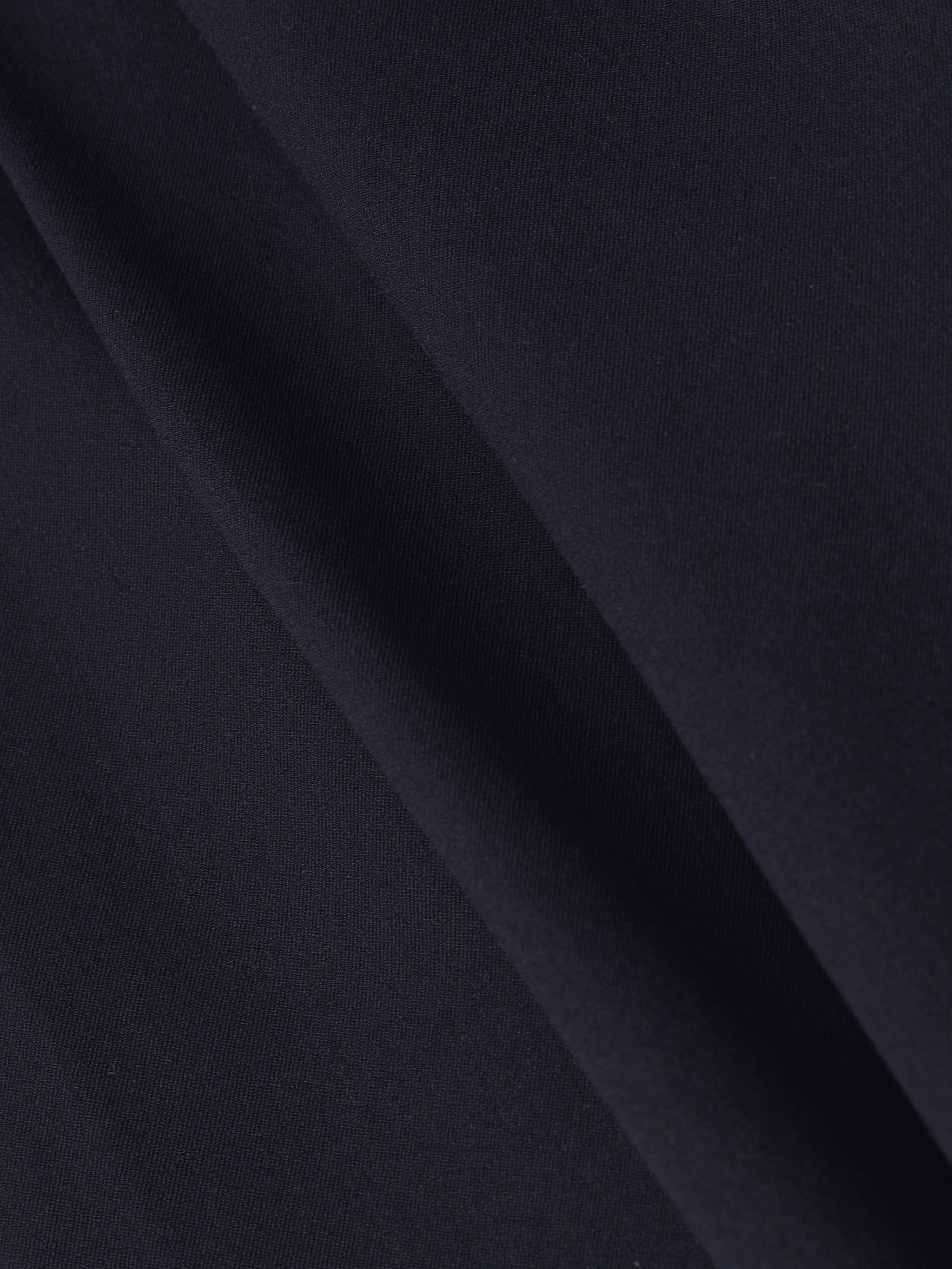 Close-up of the Chelsy Wide-Leg Pant in dark navy blue stretch fabric, featuring a diagonal crease that highlights the smooth texture and subtle folds.