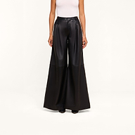 A person wearing a white sleeveless top and the Chelsy Leather Wide-Leg Pant in a high-rise, wide-leg lambskin leather style stands against a plain white background.