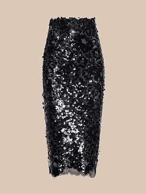 The Makena Sequin Pencil Skirt is a high-waisted, knee-length black skirt adorned with sparkling sequins, making it the perfect choice for your next party. Shown here against a stylish beige background.