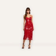 A woman wearing a red sequined Makena Sequin Pencil Skirt midi party dress with thin straps and black heeled sandals.