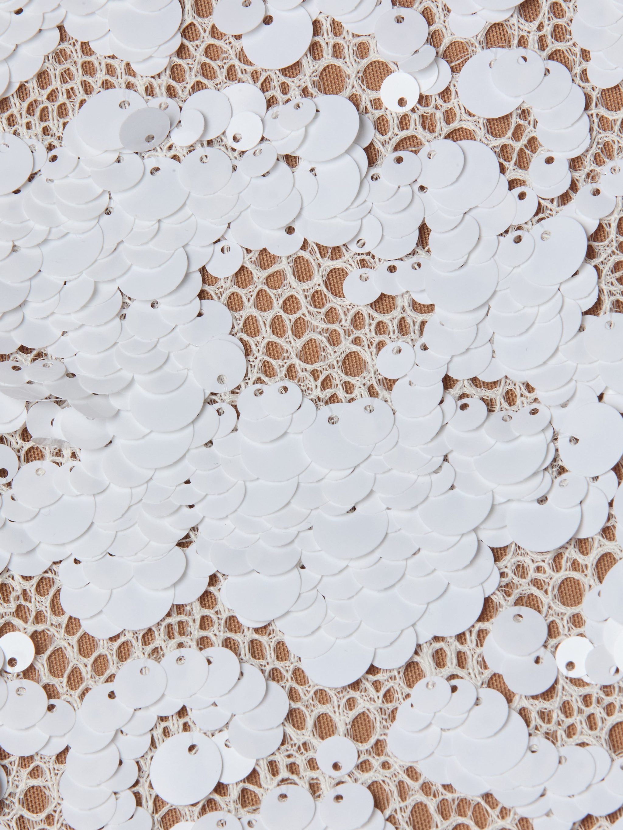 Densely sewn white sequins on beige lace fabric create a textured, decorative pattern with a blend of shiny and matte surfaces—perfect for elevating the Makena Sequin Pencil Skirt or pairing with spring fashion trends.