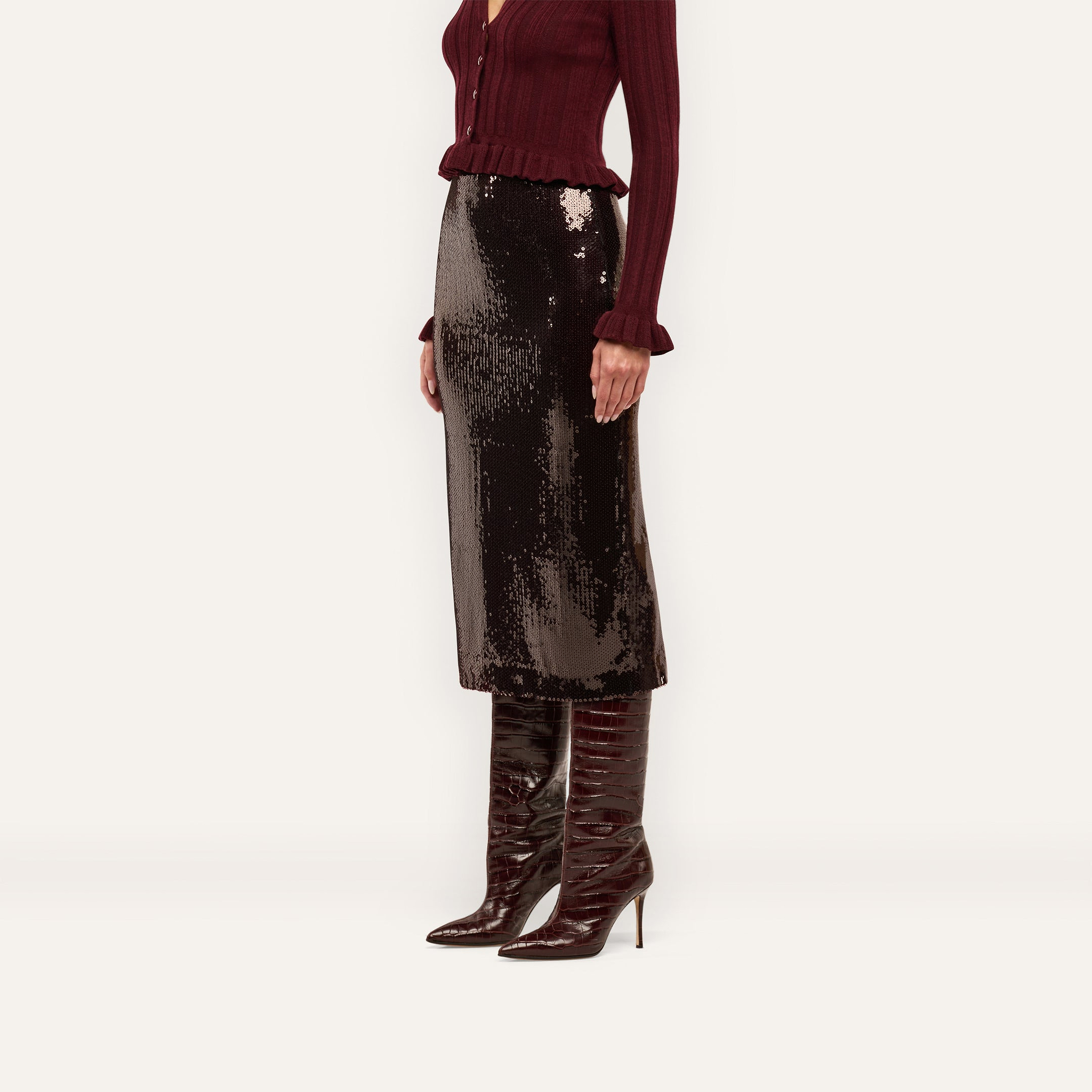 A Makena Sequin Pencil Skirt in espresso brown paired with a burgundy ribbed cardigan and tall, pointed-toe stiletto boots.