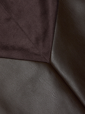 Close-up of intersecting surfaces: smooth, dark brown vegan leather meets soft, textured dark suede, forming a sharp diagonal line reminiscent of the Erma Pencil Skirt’s chic patchwork design.