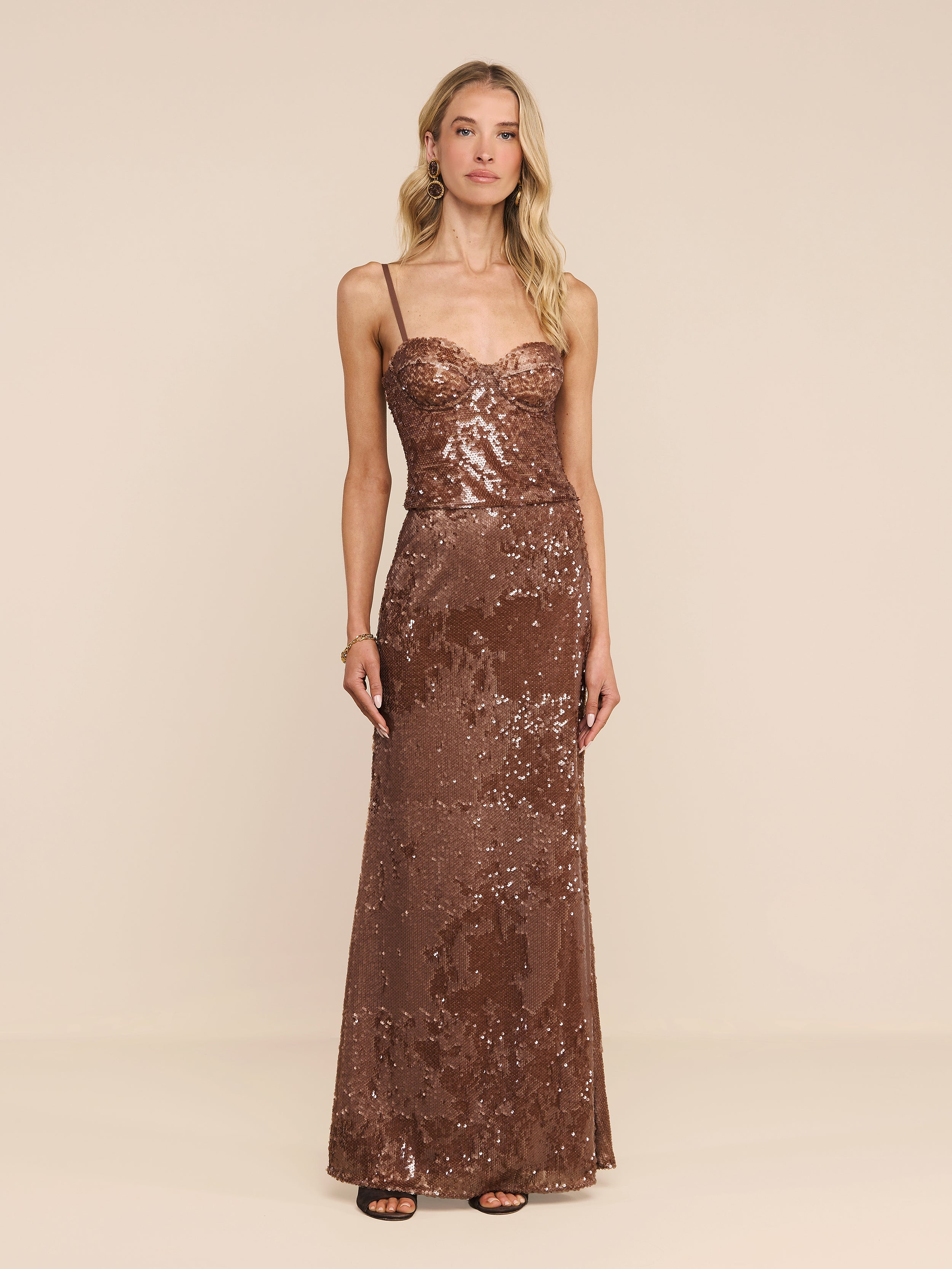 A woman wearing the Zeta Sequin Maxi Skirt with thin straps, standing against a plain white background.
