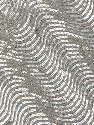 Close-up of the L'AGENCE Zeta Sequin Maxi Skirt's fabric, featuring silver sequins in overlapping, wavy patterns for a shimmering, textured look.