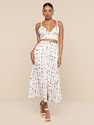 A woman wearing a white sleeveless crop top and the Seina Poplin Midi Skirt—a high-waisted, ankle-length skirt featuring a multicolored abstract print—stands against a plain white background.