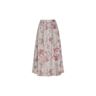 The Seina Linen Midi Skirt is a long, flowy linen skirt with a high waist, showcasing a pink botanical and palm tree jungle toile print on a light beige background. It features a button-down front and offers a relaxed, casual style.