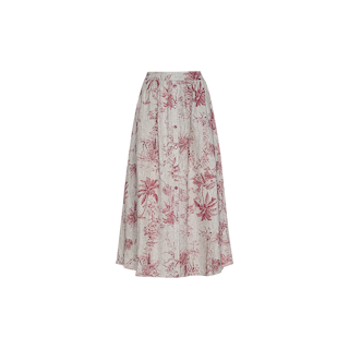 The Seina Linen Midi Skirt is a long, flowy linen skirt with a high waist, showcasing a pink botanical and palm tree jungle toile print on a light beige background. It features a button-down front and offers a relaxed, casual style.
