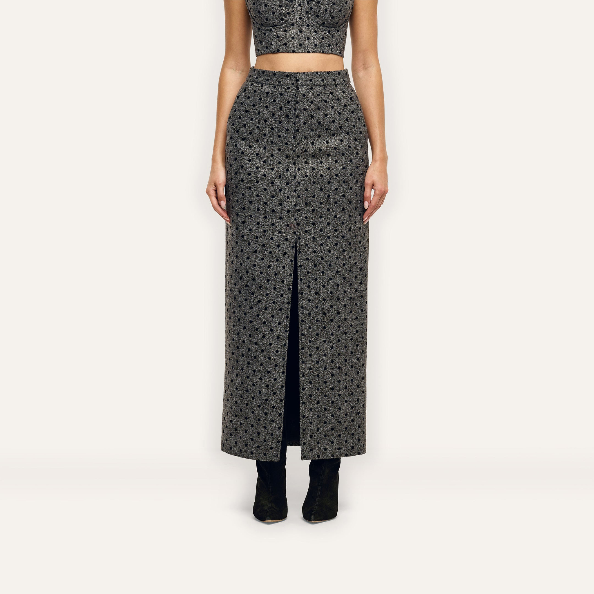 Maceline Maxi Skirt, a high-waisted velvet polka dot maxi skirt in grey and black with a front center slit.