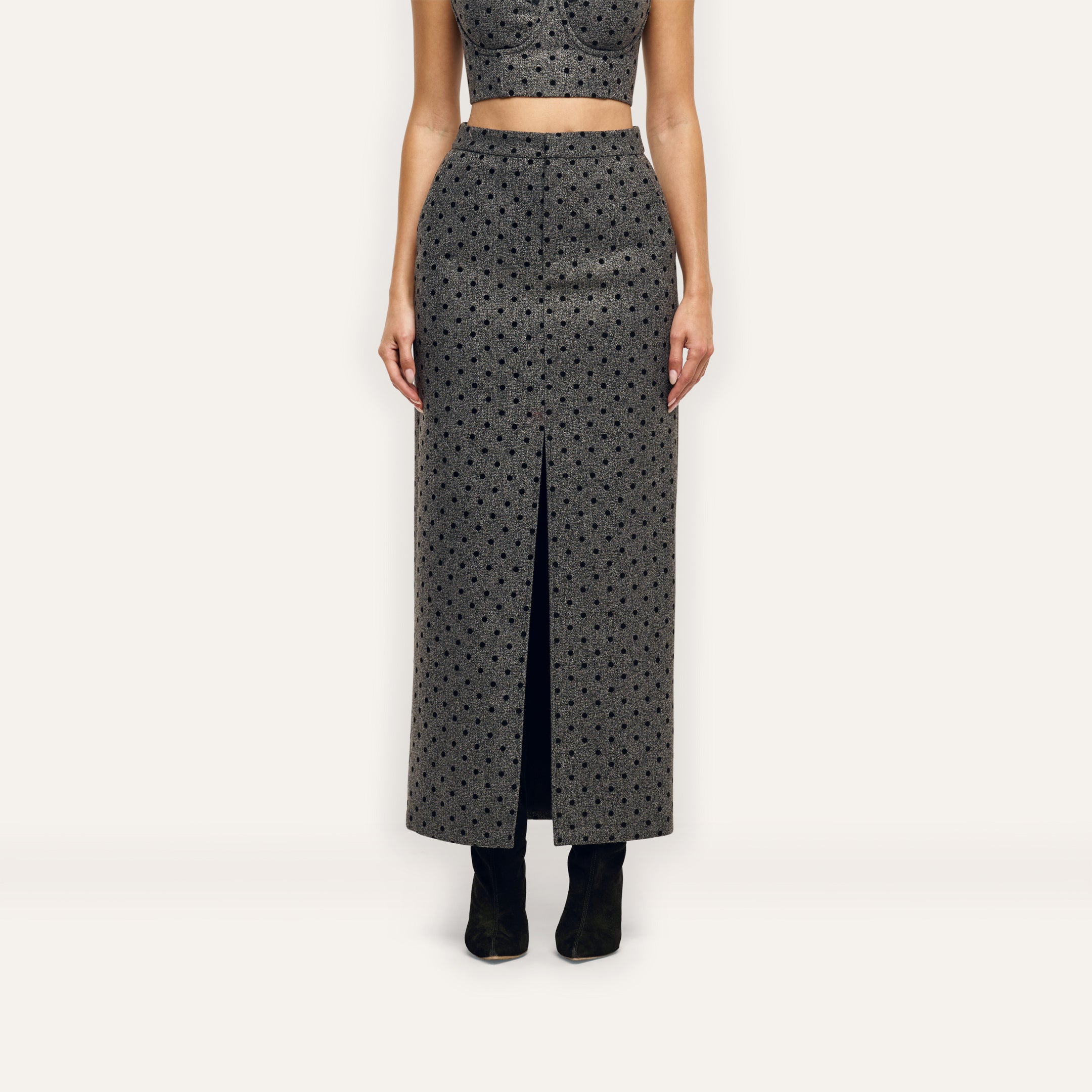 Maceline Maxi Skirt, a high-waisted velvet polka dot maxi skirt in grey and black with a front center slit.