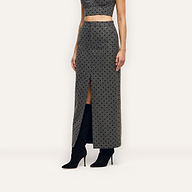 Maceline Maxi Skirt, a grey pencil skirt featuring a black velvet polka dot pattern and a front center slit, worn with black knee-high boots.