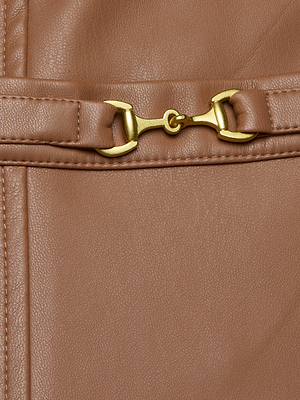 Close-up of the Yvette Vegan Leather Mini Skirt in brown, highlighting its stitched seam and decorative gold horsebit hardware on the surface.