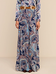 A person wearing the Patrica Maxi Skirt in a midnight blue paisley print with a tan belt, standing against a plain white background. Only the body below the shoulders is visible.