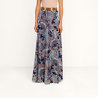 A person wearing the Patrica Maxi Skirt, a high-waisted midnight blue paisley print maxi skirt, paired with a wide brown belt, stands against a plain white background.