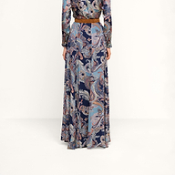 A person is shown from the back, standing against a plain white background, wearing the Patrica Maxi Skirt in midnight blue paisley print with a brown belt.