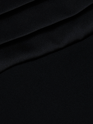 Close-up of folded black fabric with a smooth, matte texture and subtle diagonal lines—perfect for the Honesty Maxi Skirt by L'AGENCE, featuring an elegant satin waistband for a refined evening look.