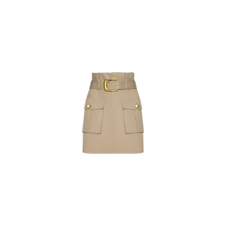 The Maelis Mini Skirt in beige cotton twill features a wide belt with a gold buckle and two spacious cargo pockets adorned with gold buttons, shown against a plain white background.