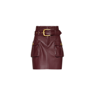 Maelis Vegan Leather Skirt in burgundy, featuring a high-waisted mini silhouette, two front cargo pockets, gold-tone hardware, and a matching belt with a large gold buckle.