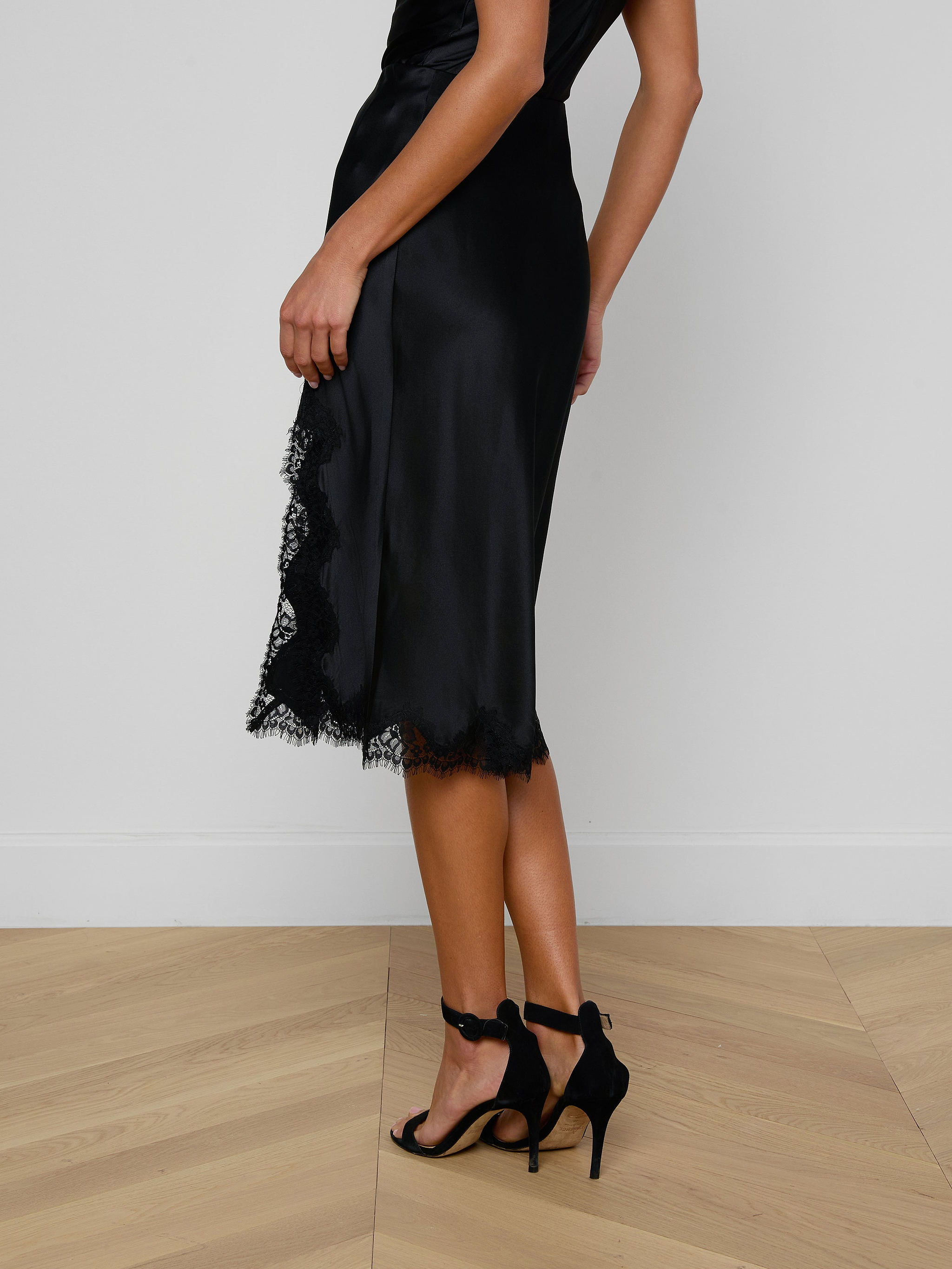 A person wearing the Tico Silk Lace Skirt and black high-heeled sandals stands against a plain light background.