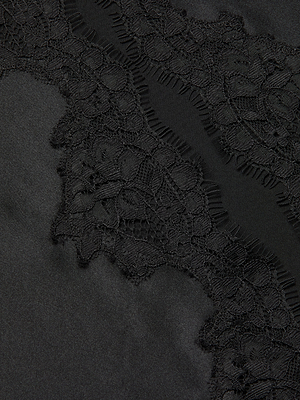 Close-up of black eyelash lace trim on smooth black fabric, showcasing the Tico Silk Lace Skirt’s intricate floral patterns and delicate contrast—an elegant choice for Spring 2026.