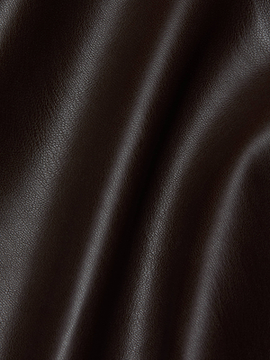Close-up of coffee brown vegan leather on the L'AGENCE Lilou Skirt, with soft folds and a smooth, subtly shiny texture. Light highlights the natural grain and creases, evoking the luxe feel of this high front slit design.