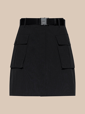 La minigonna in nylon Norene è una minigonna cargo nera, idrorepellente, con due ampie tasche anteriori con patta, bottoni e unampia cintura con fibbia rettangolare in metallo, su sfondo beige.
