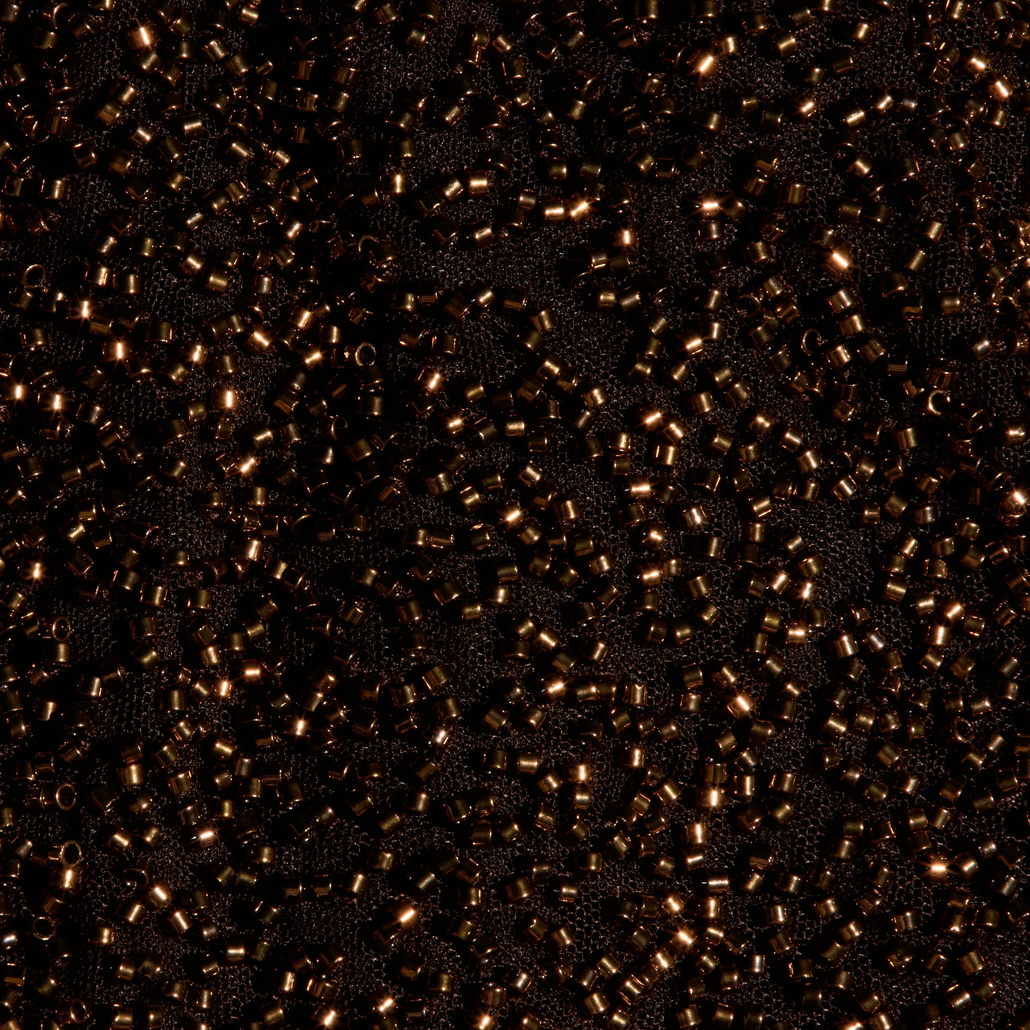 Close-up of the Dravenne Beaded Skirt, featuring dark fabric mesh densely covered in metallic brown cylindrical beads.