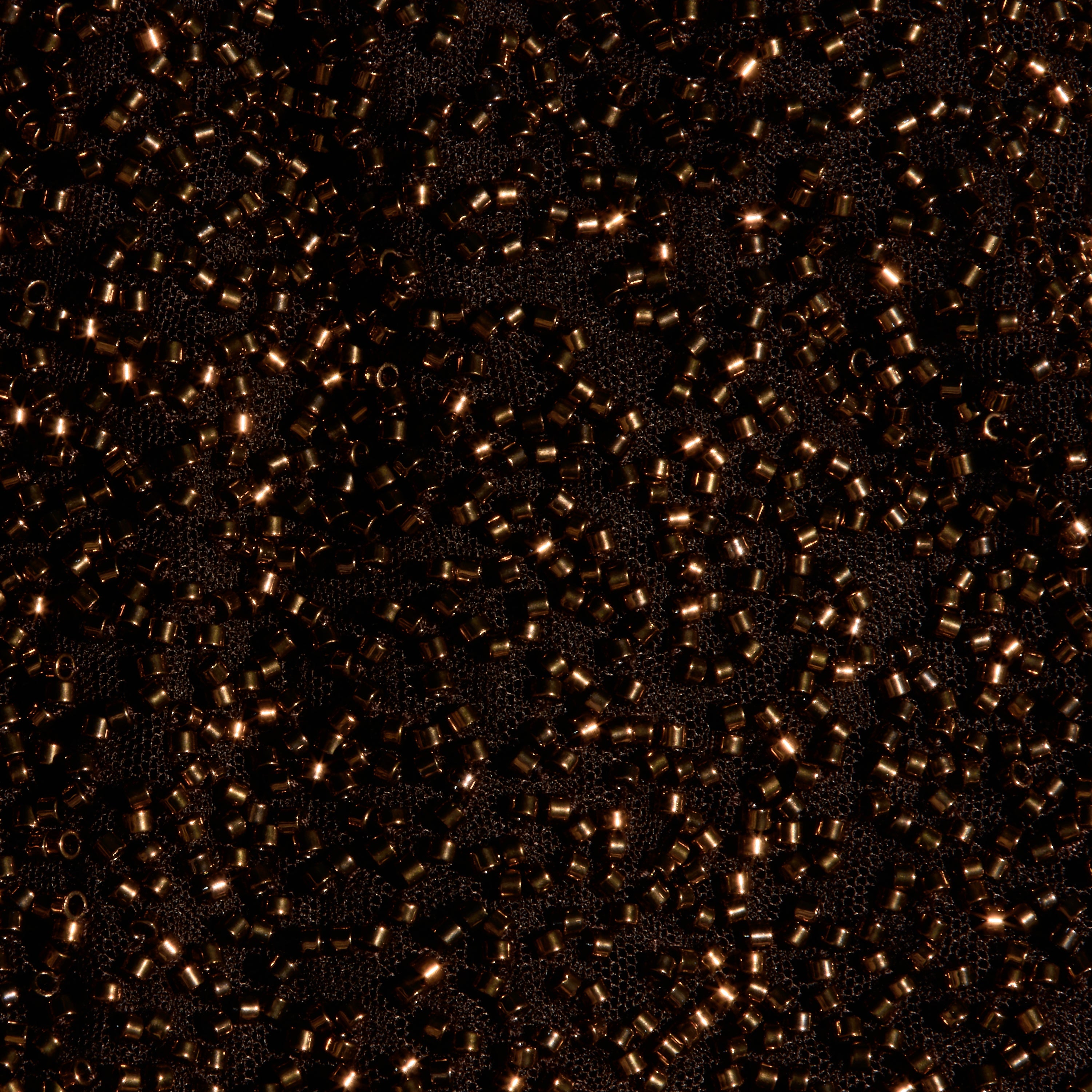 Close-up of the Dravenne Beaded Skirt, featuring dark fabric mesh densely covered in metallic brown cylindrical beads.