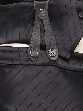 Close-up of the Vespera Suspender Maxi Skirt in black pinstripe, highlighting its textured fabric, visible buttons, leather straps, and adjustable suspenders for a detailed look at the garment’s fastening.