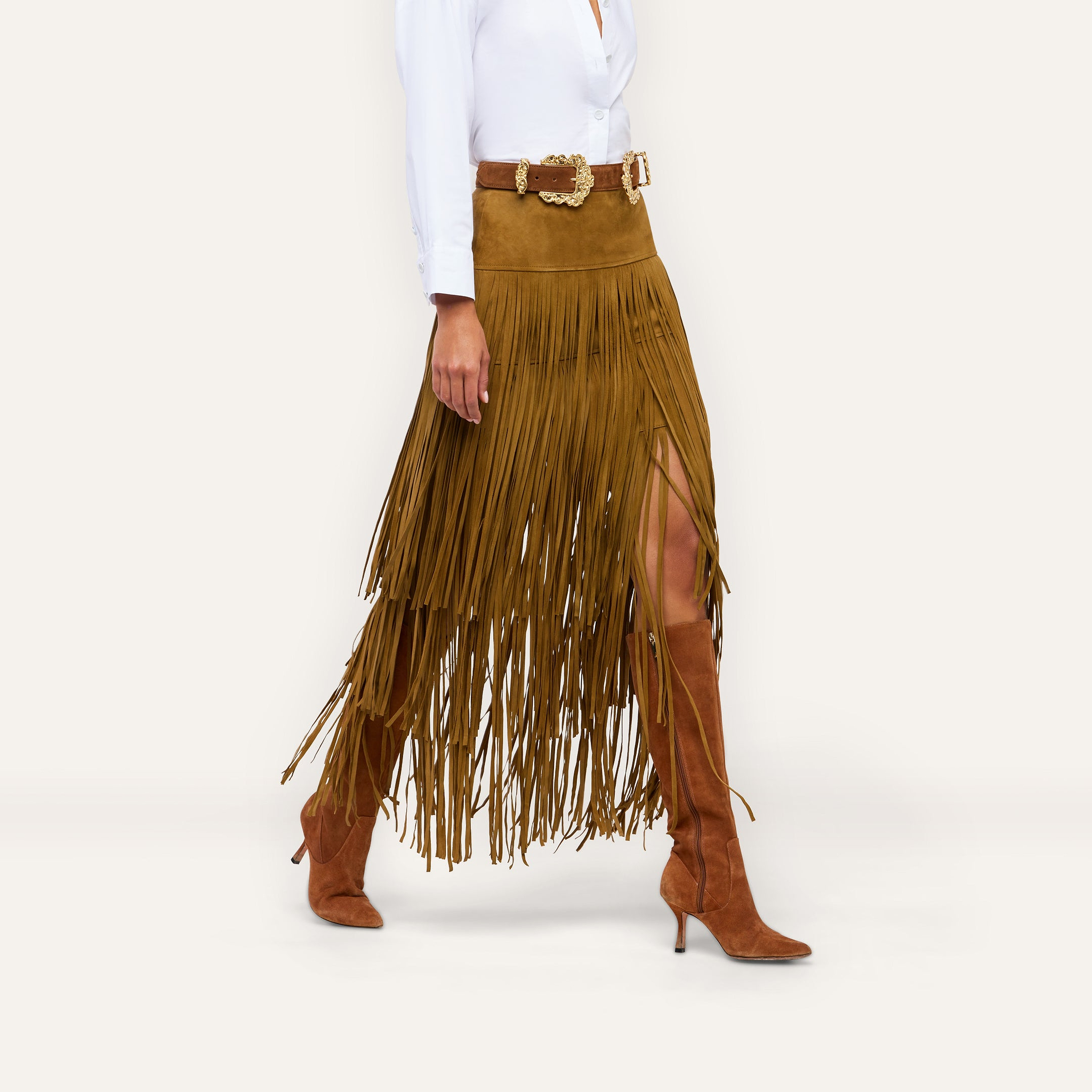Karoline Suede Fringe Skirt in brown suede, featuring layered fringe detailing and a statement design, worn with a brown belt and knee-high boots.