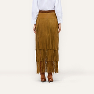 A person wears a white button-down shirt tucked into a Karoline Suede Fringe Skirt paired with brown suede heeled boots.